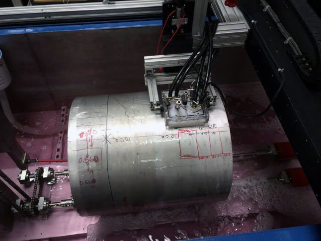 Close-up of SDI ultrasonic scan head inspecting a marked cylindrical part